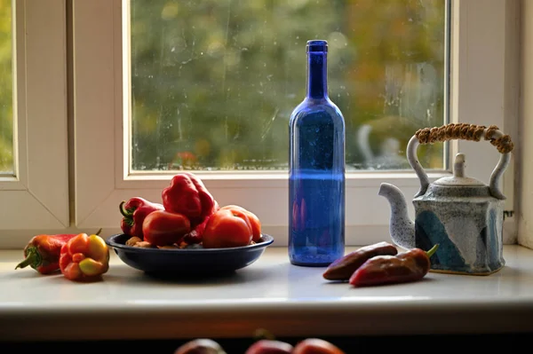 Şişede taze organik domates ve mutfakta su.