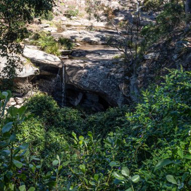 Dağ şelalesi küçük bir dereden Glenrock Rezervi 'ndeki Burwood sahiline akıyor.
