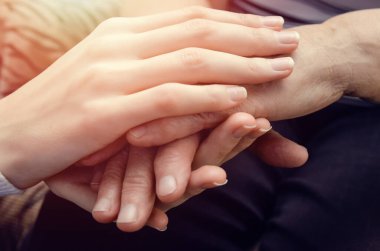 Yaşlı, yaşlı bir kadının elini tutan genç bir kızın elleri. İki kuşak kadın konsepti