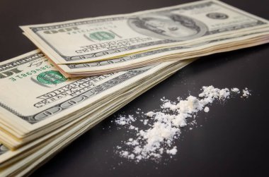 Dolarlar ve dağınık uyuşturucular yakın planda siyah bir arkaplanda. bağımlılık kavramı