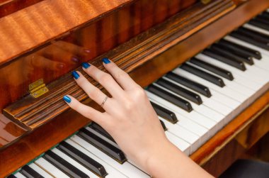 Piyanist kız çalmak için piyanonun kapağını açar.