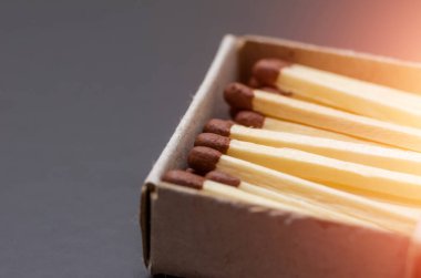 Kutudaki kibritler, koyu arkaplan. Makro fotoğrafçılık. Yakın plan çekim. Açık kibrit kutusundaki siyah arkaplanda işaret fişeği ile eşleşir
