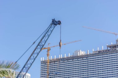 Batumi 'de çok katlı binaların yapımı. Binaların arka planında inşaat vinçleri var. Mavi gökyüzüne karşı katlı bina.
