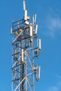 Mobil iletişim kulesi mavi gökyüzüne yakın çekim, dikey fotoğraf