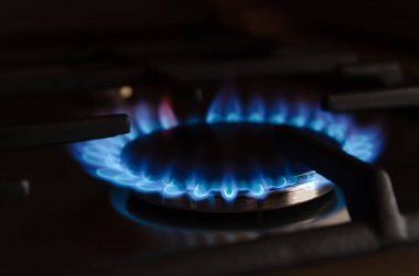 Gaz sobasının üzerinde mavi gaz alevi var.