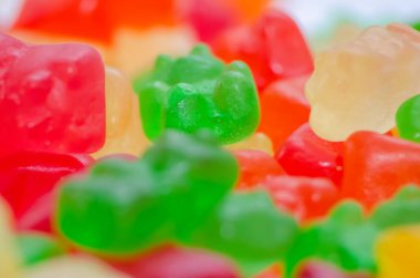 Mavi arka planda bir sürü renkli jöle ayısı, makro