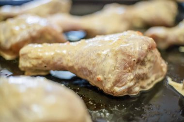 Çiğ tavuk bacağı, terbiye edilmiş baharatlı bacaklar. Bir çiğ tavuk bacağına odaklan..