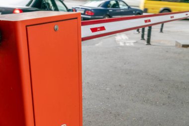 Avluda gündüz saatlerinde otomatik kırmızı-beyaz bariyer var.