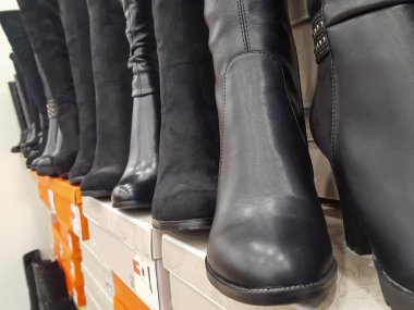 Mağazanın rafında kadın botları var. Yakın plan.