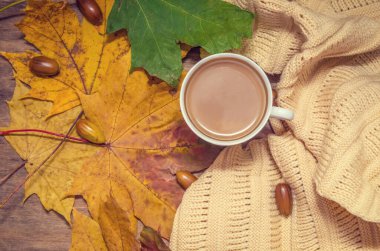 Sonbahar havası. Beyaz kahve ve sarı akçaağaç yaprağı, sarı eşarp. en üstteki görünüm