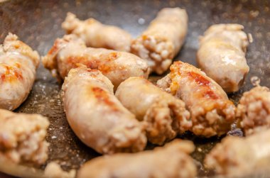 Kızartma tavasında kızartılmış sosisler.