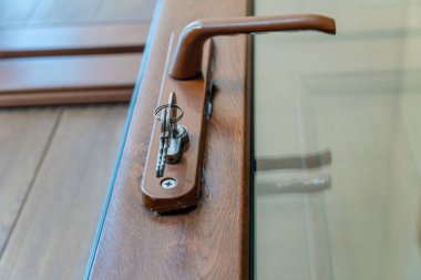 İç kapı kolu ve anahtar kilidinin yakın plan görüntüsü. Giriş ya da balkon kapısı, fotoğraf dışarıda.