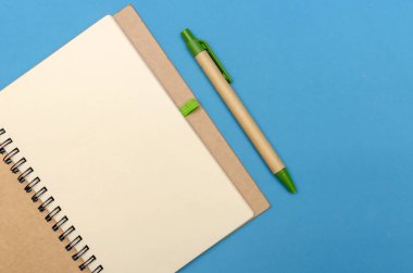 Mavi arka planda kalem ve hediyeyle Notepad 'i aç. Düz konum, üst manzara. Tatil konsepti, Sevgililer Günü, Noel, Yeni Yıl
