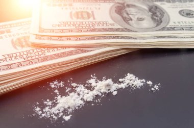 Dolarlar ve dağınık uyuşturucular yakın planda siyah bir arkaplanda. bağımlılık kavramı