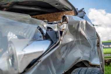 Araba kazası ya da kaza. Gri arabanın sol farları kırık. Arabanın kırık kısımları yakın plan..