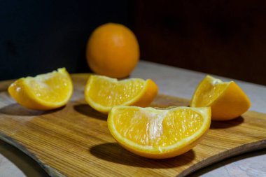 Tahta kesme tahtasındaki portakal dilimlerini kes