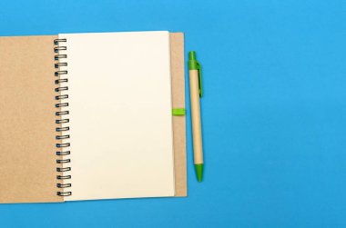 Mavi arka planda kalem ve hediyeyle Notepad 'i aç. Düz konum, üst manzara. Tatil konsepti, Sevgililer Günü, Noel, Yeni Yıl