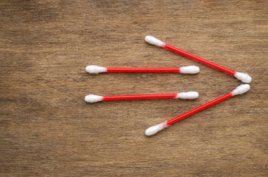 Plastik pamuklu çubuklar, ok işareti, tahta arka planda sağa yön işareti.