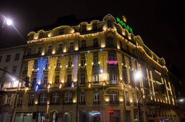 Varşova, Polonya - 25 Aralık 2018: Avrupa şehir caddesinde kış mevsimsel tatilleri boyunca ışık çelengi ile süslü bir bina