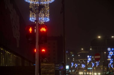 Yayalar ve bisikletçiler için kırmızı ışıklı trafik ışığı ve bir bisikletçi figürü. Dost canlısı bir şehirde bisikletçilerin durduğu bir gece..