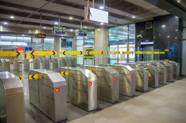İnsanlar metroda turnikeden geçiyorlar. Metrodaki yolcular. Turistler turistik tren istasyonunda yürürler. Metro istasyonu turnikeleri. Metro istasyonu turnikelerine giriş..