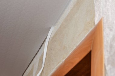 İşçi, odanın tavanını çeker ve kenarın çevresini sarar.