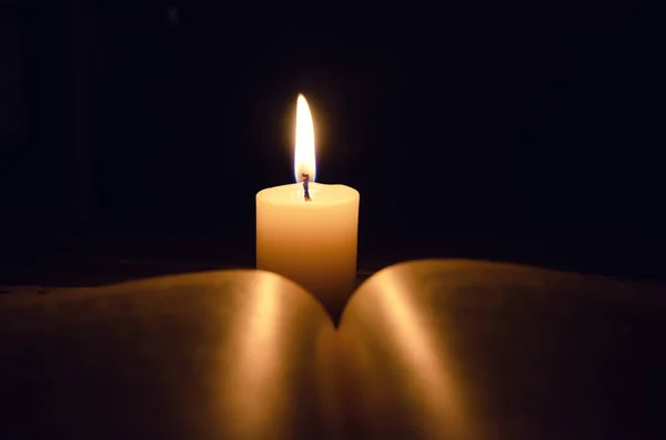 Αναμμένο Κερί Και Ένα Βιβλίο Ένα Τραπέζι Στο Σκοτάδι Ένα — Φωτογραφία Αρχείου