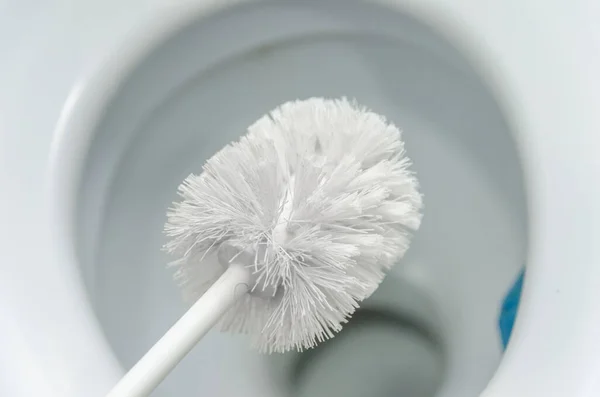 Großaufnahme Einer Weißen Toilettenbürste Über Einer Weißen Toilettenschüssel Das Konzept — Stockfoto