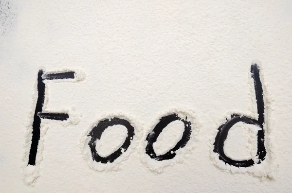 用面粉写在黑色背景上的食物 — 图库照片