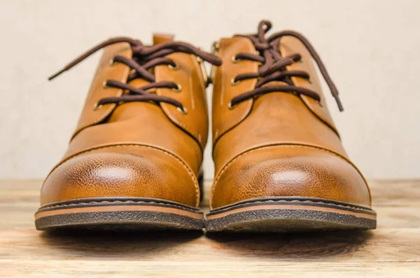 Brown leather men  shoes on a wooden background close up