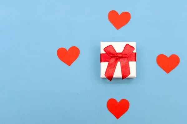 Κουτί Δώρου Ανάμεσα Κόκκινες Χάρτινες Καρδιές Μπλε Φόντο Πάνω Όψη — Φωτογραφία Αρχείου