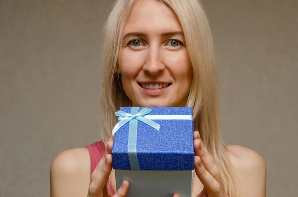 Ragazza Bionda Con Sorriso Che Tiene Una Scatola Regalo Blu — Foto Stock