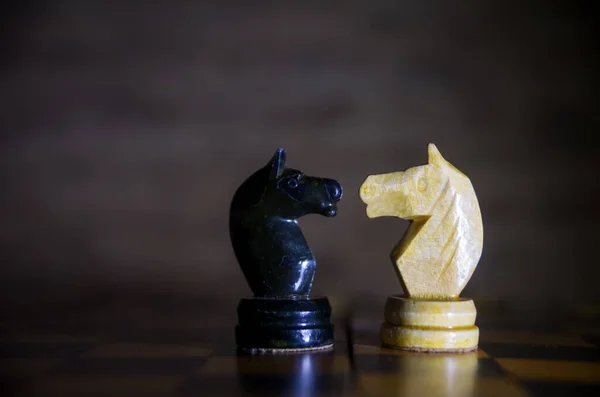 国际象棋的马在彼此面前 棋盘上的黑马和白马 靠近点 — 图库照片