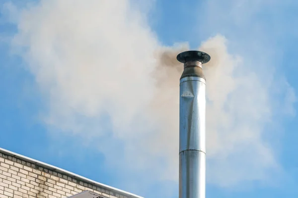 Smoke from the chimney against the blue sky. Pipe with smoke. Emissions of pipes into the atmosphere. Harmful emissions into the atmosphere. concept of ecology