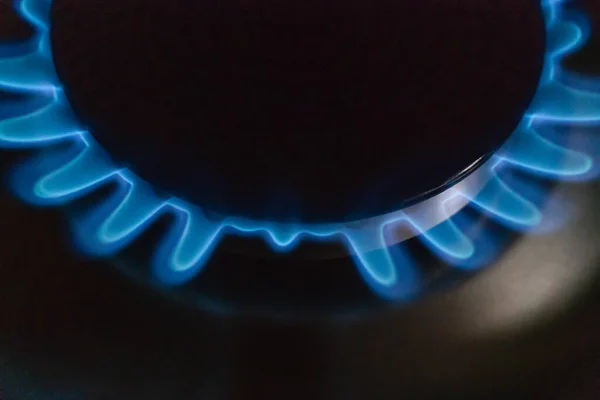 Blue flame of burning gas on a gas stove macro