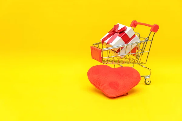 Geschenkkarton Warenkorb Auf Gelbem Hintergrund Neben Roten Herzen Kopierraum Konzept — Stockfoto