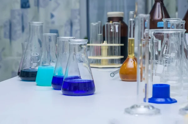 Laboratóriumi Üvegáru Többszínű Folyadékkal Asztalon Kémiai Elemzés — Stock Fotó