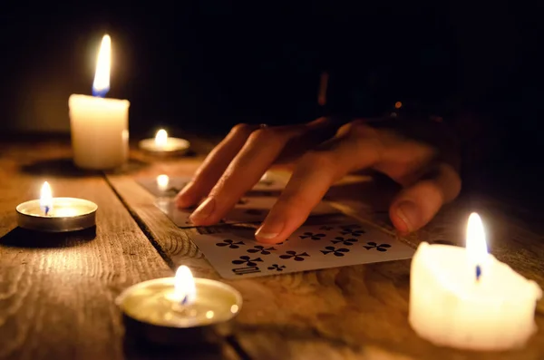 一个算命先生的手和卡片在桌子上 在黑暗中点燃的蜡烛周围的木制桌子上 占卜的概念 — 图库照片