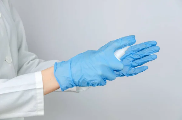 Доктор Белом Халате Голубых Перчатках Дезинфицирует Руки Антисептическим Спреем Вблизи — стоковое фото