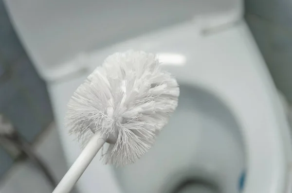 Großaufnahme Einer Weißen Toilettenbürste Über Einer Weißen Toilettenschüssel Das Konzept — Stockfoto