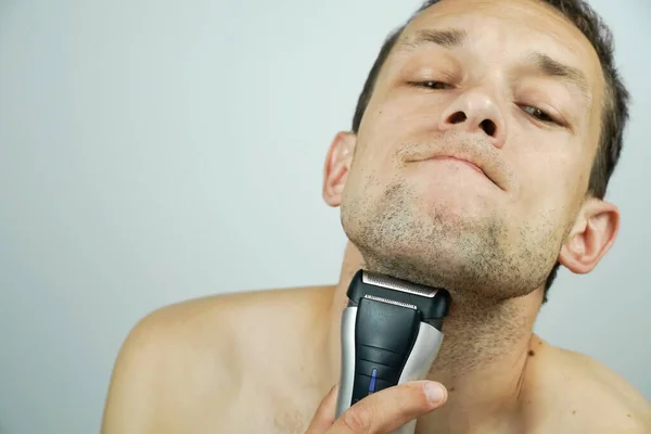 Dark Haired Beautiful Man Shaves Electric Razor Makes Faces Camera — Stock Photo, Image