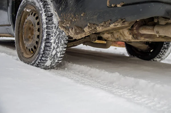 The car tire in the snow close up. Car tracks on the snow. Traces of the car in the snow. Winter tires. Tyres covered with snow at winter road — Stock Image Car Tire Snow Close Car Tracks Snow Traces Car Snow Stock Picture