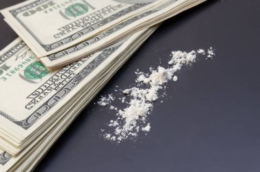 Dolarlar ve dağınık uyuşturucular yakın planda siyah bir arkaplanda. bağımlılık kavramı