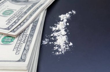 Dolarlar ve dağınık uyuşturucular yakın planda siyah bir arkaplanda. bağımlılık kavramı