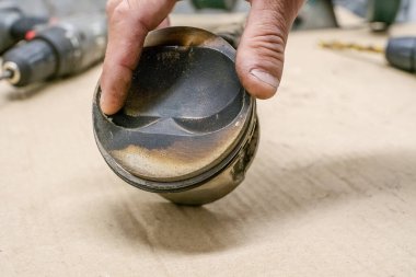 Bir araba tamircisinin elinde kullanılmış piston.