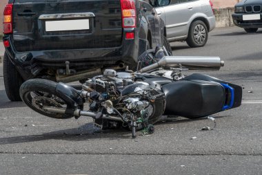 Kırık motosiklet, arabanın yanında yakın plan. Güneşli bir günde, bir motosiklet ve bir arabanın karıştığı yolda bir kaza..