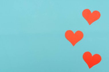 Mavi arka planda kırmızı kağıt kalpler. Üst görünüm, boşluğu kopyala. Sevgililer Günü, aşkın sembolü. Neşeli arkaplan