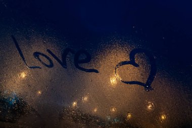 Yazıtlara göre sisli camlarda aşk, arka planda gece lambaları sallanıyor