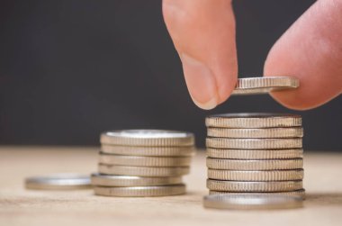 Para yığını büyüyen iş. Siyah arka planda gümüş paraları üst üste istifle. Geleceğe hazırlık için para biriktir