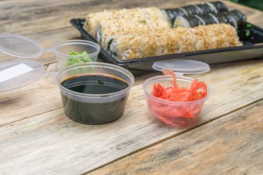 Ahşap arka planda sushi Toto Maki, Bonito Maki, Akito Maki soya soslu, zencefil ve wasabi hazırla. Üst görünüm, yan görünüm